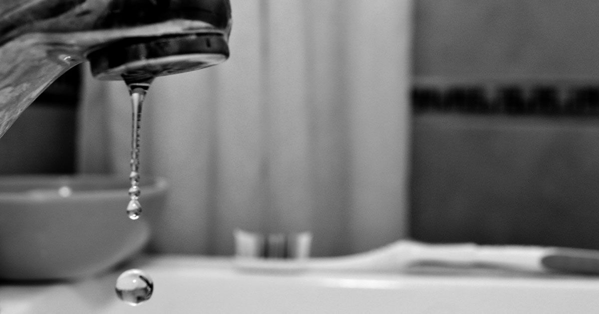 Leaky bathroom faucet dripping water.